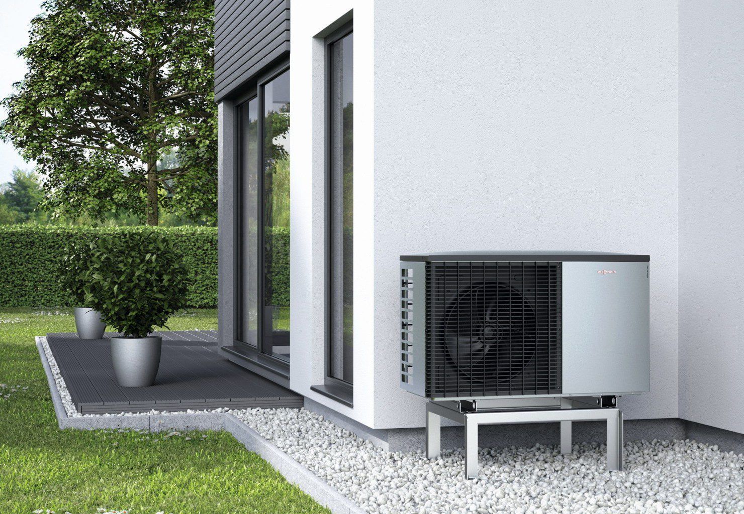 Unité extérieure de pompe à chaleur air/eau posée sur un support devant une maison individuelle
